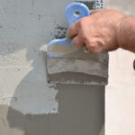 Worker preparing house for stucco installation